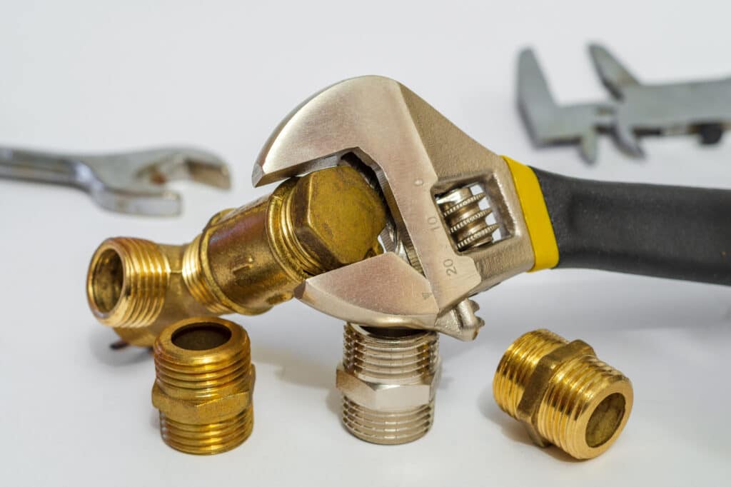 Plumbing fixtures refer to a set of fittings and tools, including adjustable spanners, used to connect water and gas installations. These fixtures are essential for ensuring proper connections and functionality in plumbing systems.