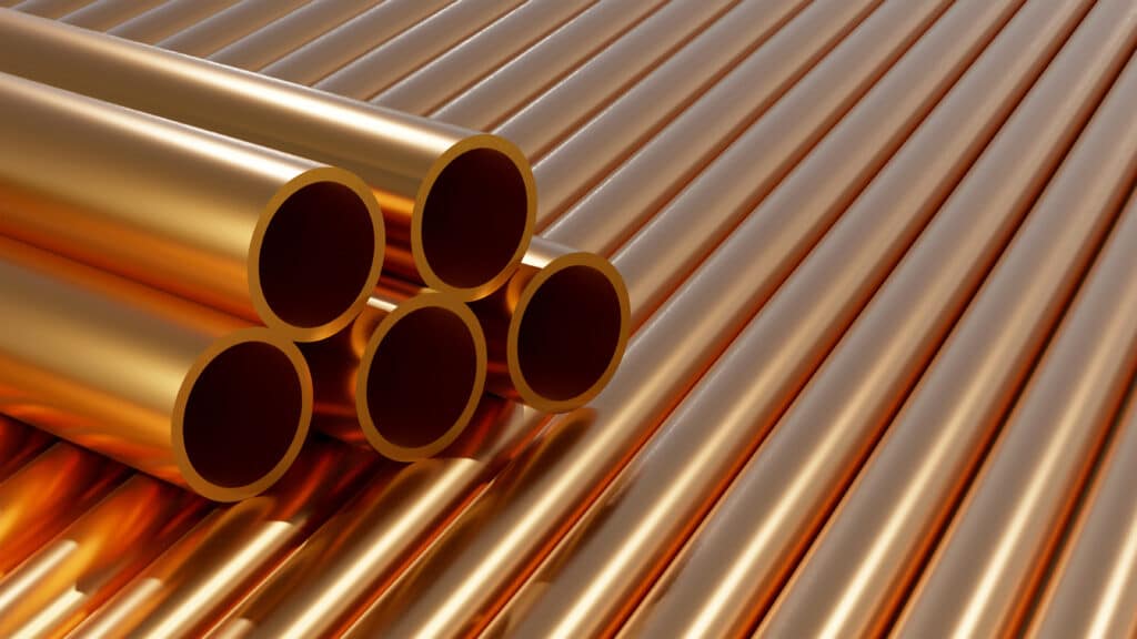 Group of simple, new, high-quality, shiny copper piping for plumbing and heating systems. Metal alloy pipes stacked as industrial construction materials and supplies.
